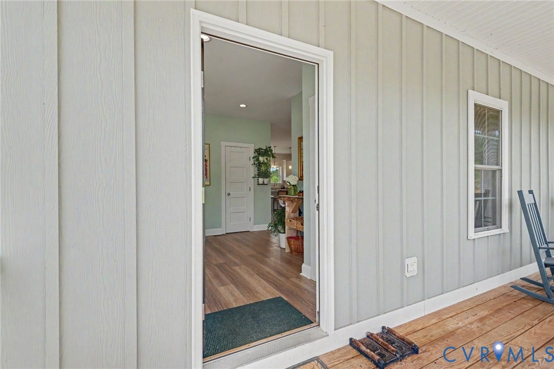 815 Kennon Road, Northeast Creek Reservoir Subd, Mineral, VA 23117 Covered porch entry featuring wood-finish flooring, vertical board siding, and a white trim window