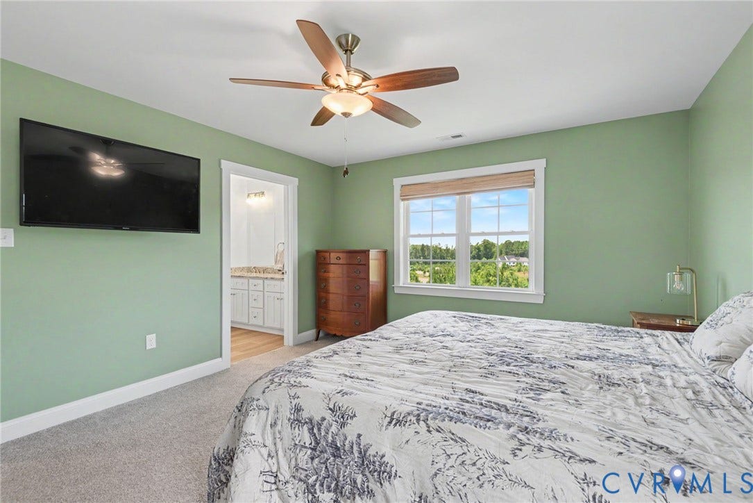 815 Kennon Road, Northeast Creek Reservoir Subd, Mineral, VA 23117 Carpeted room featuring a ceiling fan with light fixture, ample natural light from a window, and a walk-in closet and en-suite bath