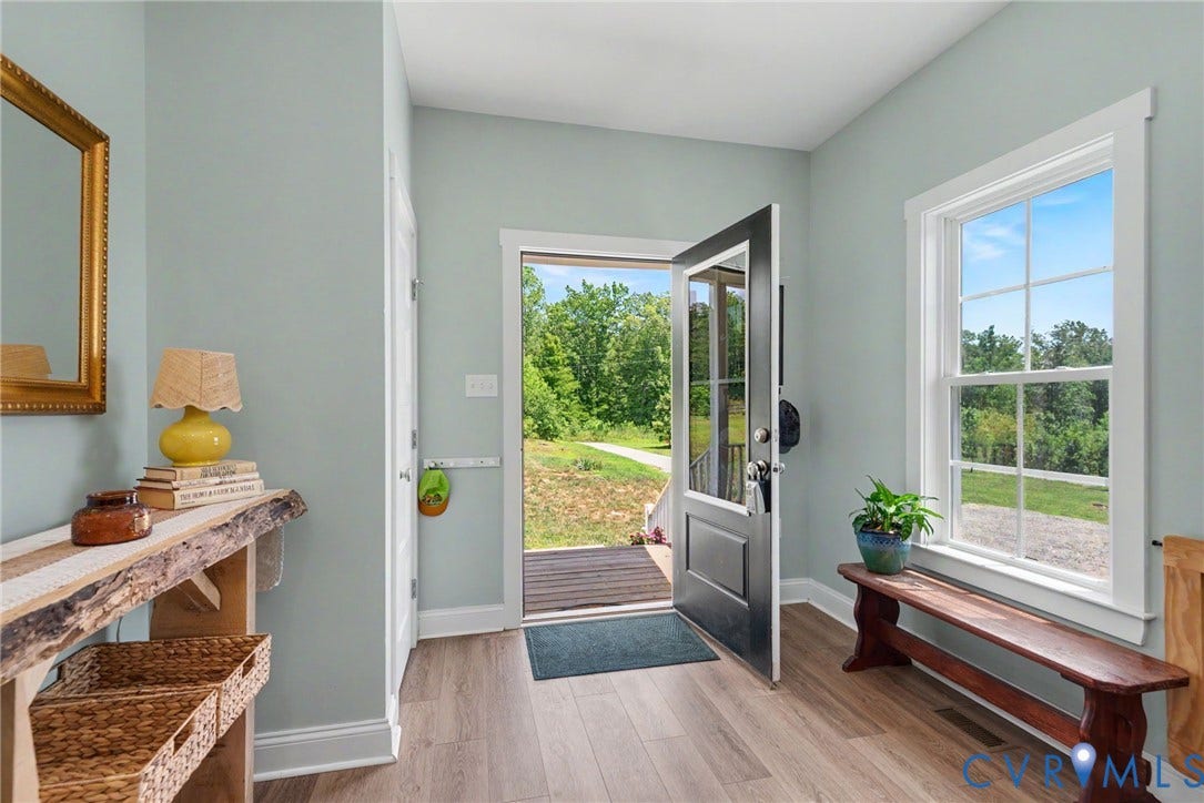 815 Kennon Road, Northeast Creek Reservoir Subd, Mineral, VA 23117 Entryway featuring wood-finish flooring, a black paneled door with glass inserts, and a multi-pane window