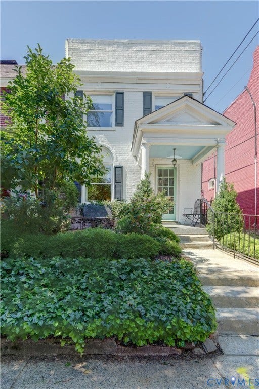 2619 Grayland Avenue, Byrd Park/Upper Fan, Richmond, VA 23220 White brick facade featuring gray window shutters, an arched window, and a columned portico entrance with a light blue ceiling
