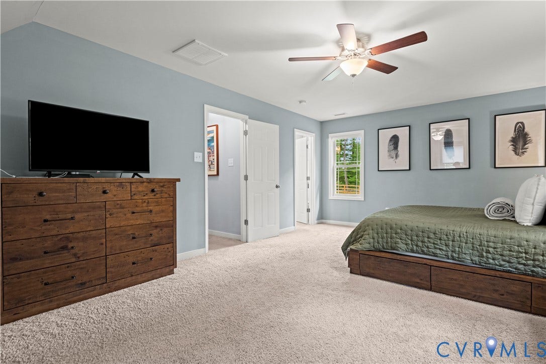 Carpeted room featuring light blue walls, a white ceiling, and a ceiling fan with integrated lighting