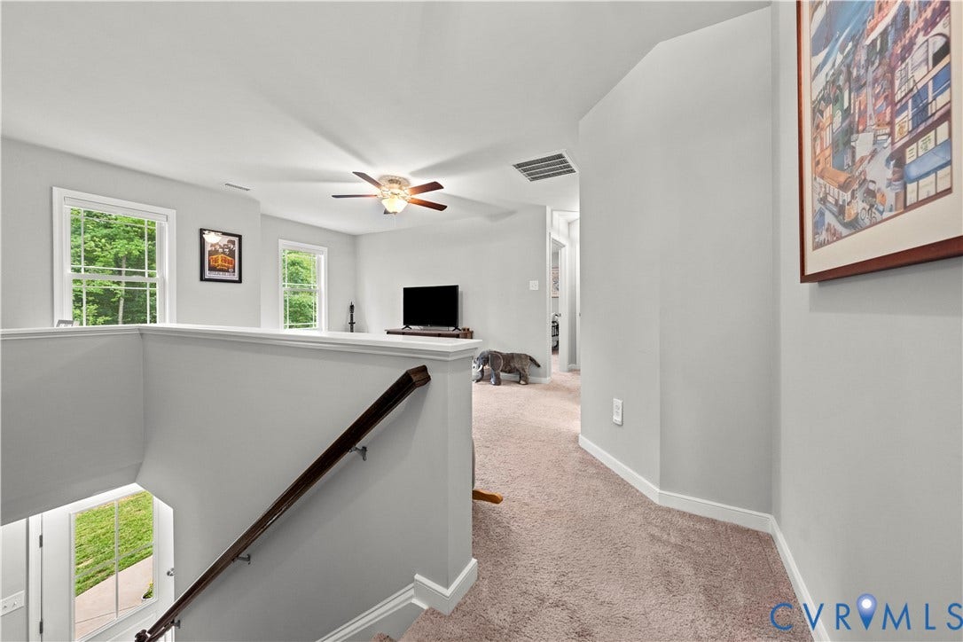 Upper level landing with neutral wall paint and carpeted flooring