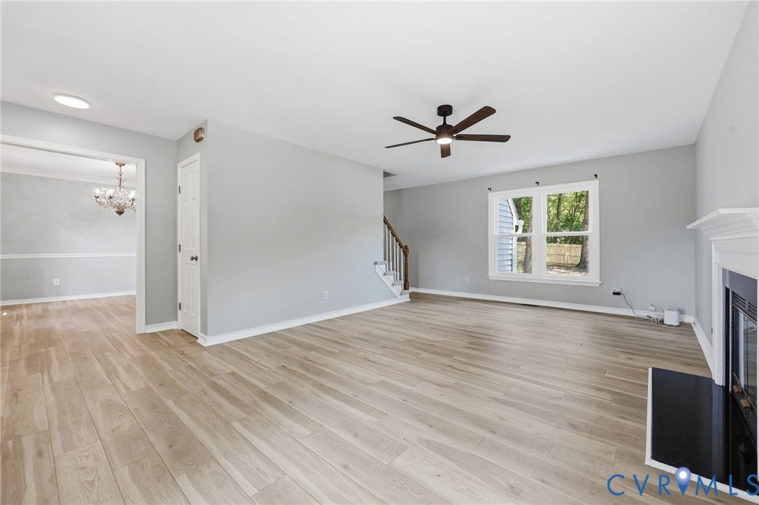 9500 Mesquite Road, Glen Allen, VA 23060 Spacious living area featuring light wood-finish flooring, a contemporary ceiling fan, and a fireplace with a white mantle