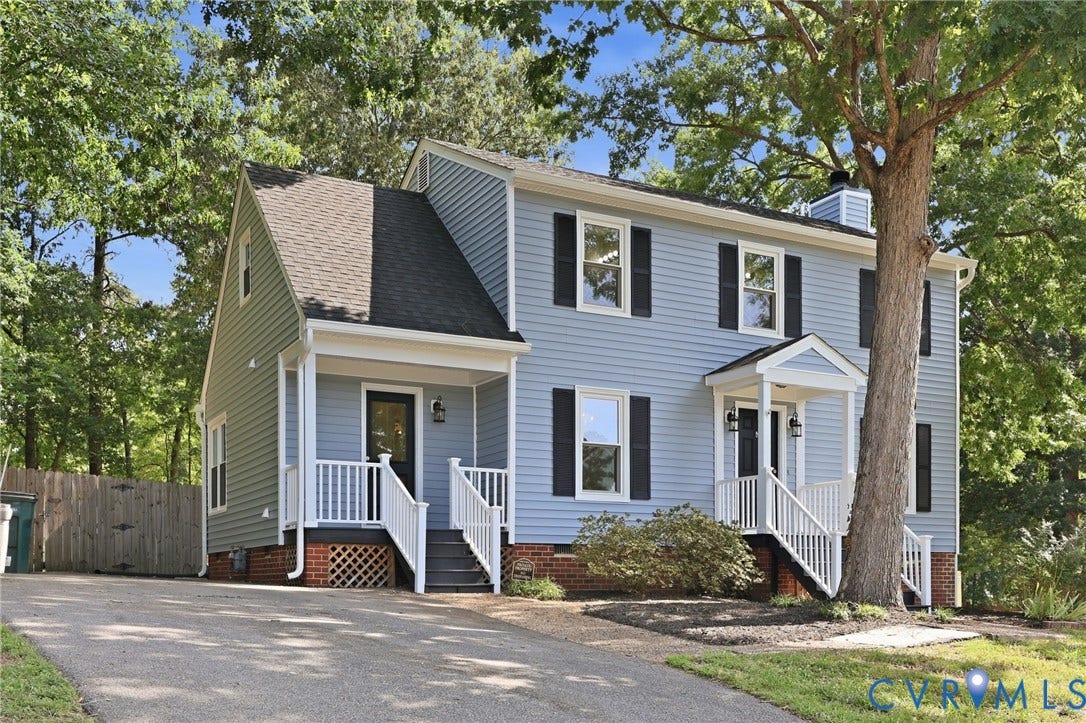 9500 Mesquite Road, Glen Allen, VA 23060 Two-story light blue siding residence featuring dual covered entryways, white railings, black shutters, and a mature tree