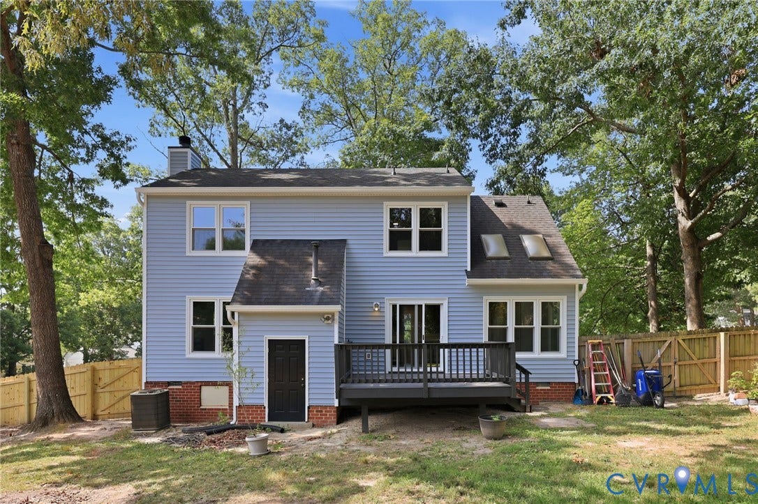 9500 Mesquite Road, Glen Allen, VA 23060 Rear exterior featuring light blue siding, multiple windows, a dark grey deck, and a wood privacy fence