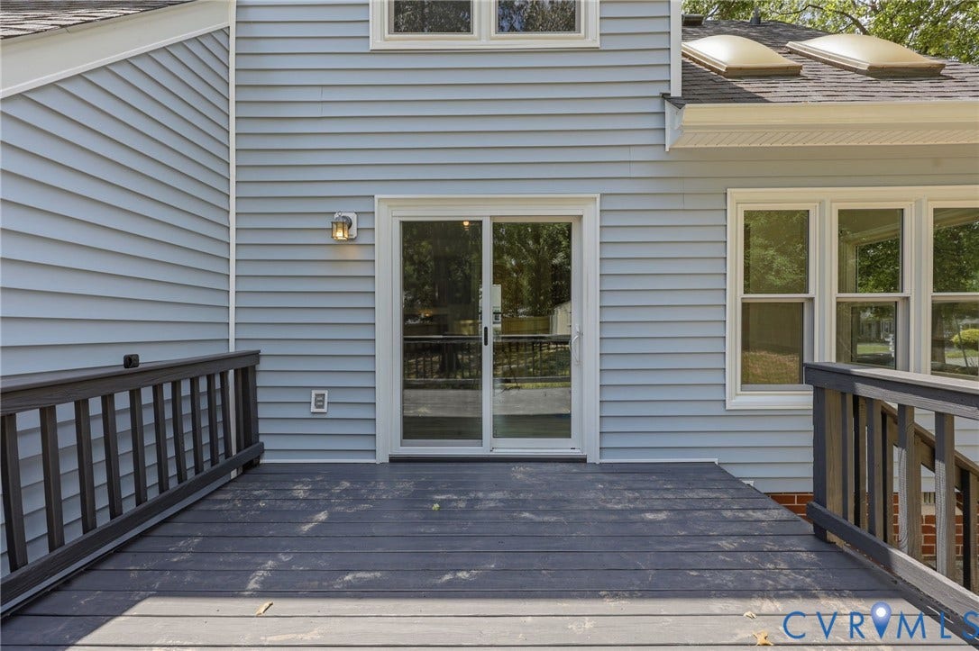 9500 Mesquite Road, Glen Allen, VA 23060 Rear exterior featuring a spacious deck with dark-stained railings, light blue horizontal siding, a sliding glass door, and multiple windows
