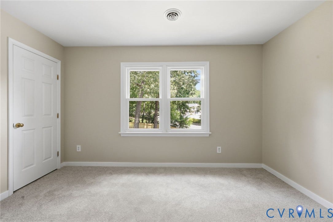 9500 Mesquite Road, Glen Allen, VA 23060 Neutral-toned room featuring a single pane window, light-colored carpet, and a white six-panel door with brass hardware
