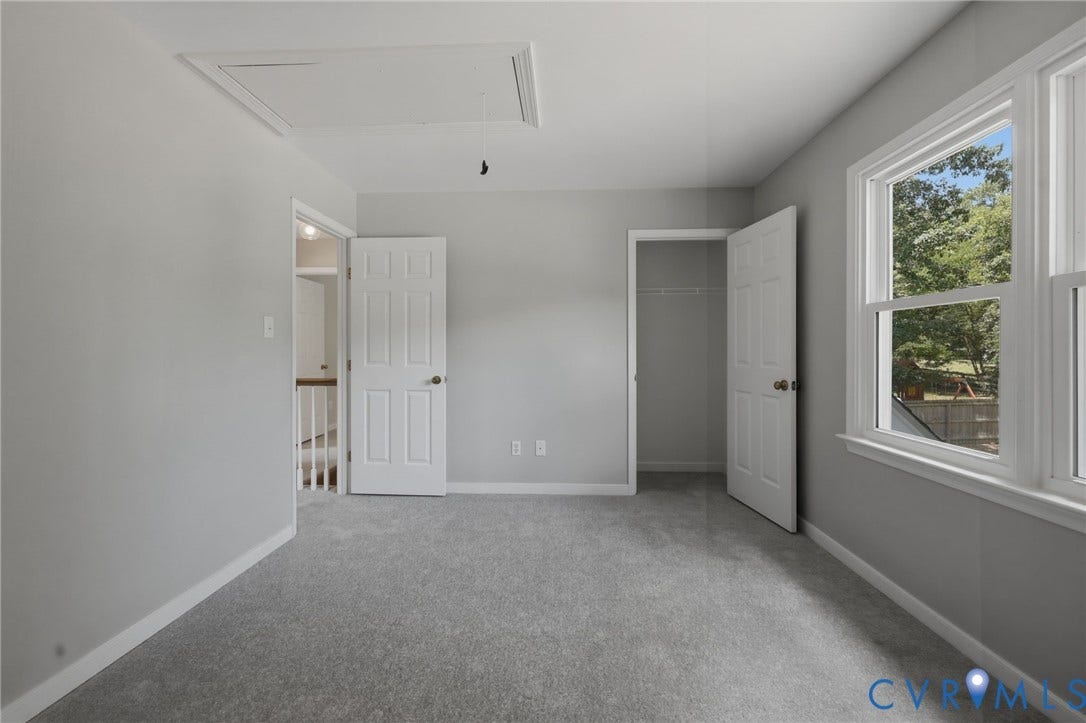 9500 Mesquite Road, Glen Allen, VA 23060 Neutral gray wall paint with white trim, new gray carpet, two double-hung windows, and a closet with a built-in shelf and hanging rod