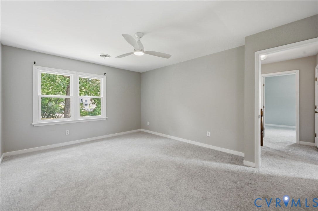 9500 Mesquite Road, Glen Allen, VA 23060 Spacious room featuring light gray carpeting and walls, a prominent double window with white trim, and a modern ceiling fan