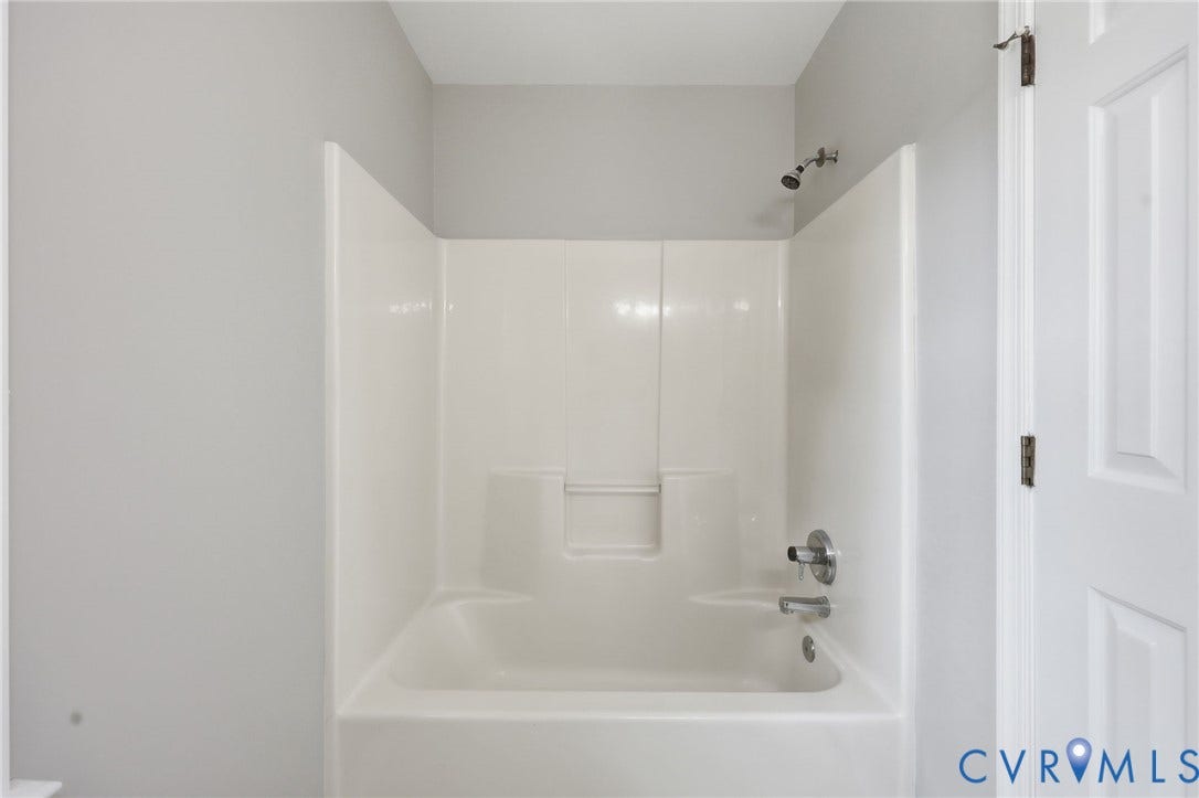 9500 Mesquite Road, Glen Allen, VA 23060 Shower and tub combination unit featuring a built-in soap shelf, chrome fixtures, and a white paneled door