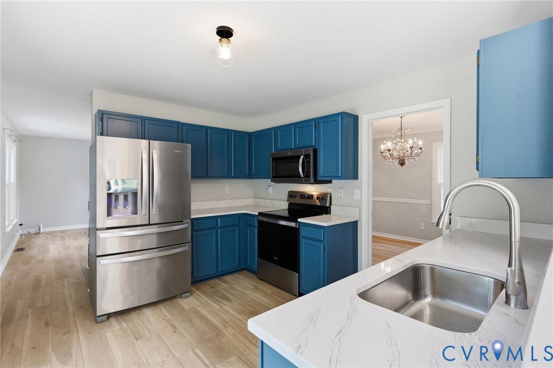 9500 Mesquite Road, Glen Allen, VA 23060 Kitchen featuring blue cabinetry, stainless steel appliances, light countertops, and wood-finish flooring