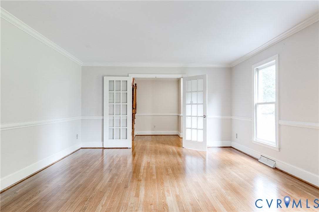 3924 Belspring Road, Chester, VA 23831 Spacious room featuring hardwood flooring, white crown molding, chair rail molding, and a double French door entry