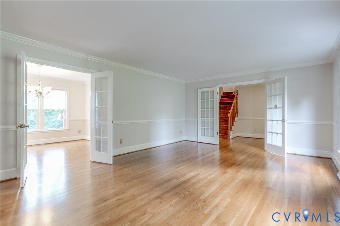 3924 Belspring Road, Chester, VA 23831 Hardwood flooring throughout the main living space with crown molding, chair rail detailing, French doors, and a visible staircase