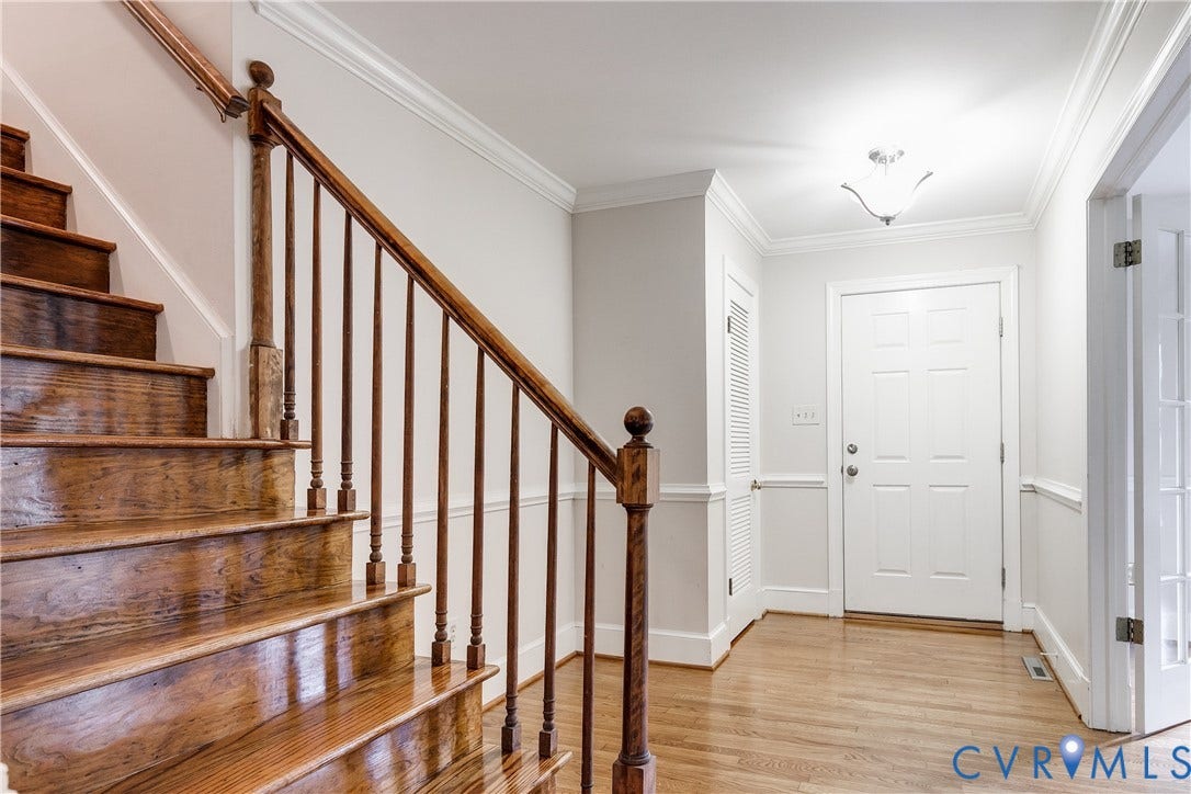 3924 Belspring Road, Chester, VA 23831 Entryway featuring hardwood flooring, a paneled front door, and a staircase with wood-finish treads and balusters