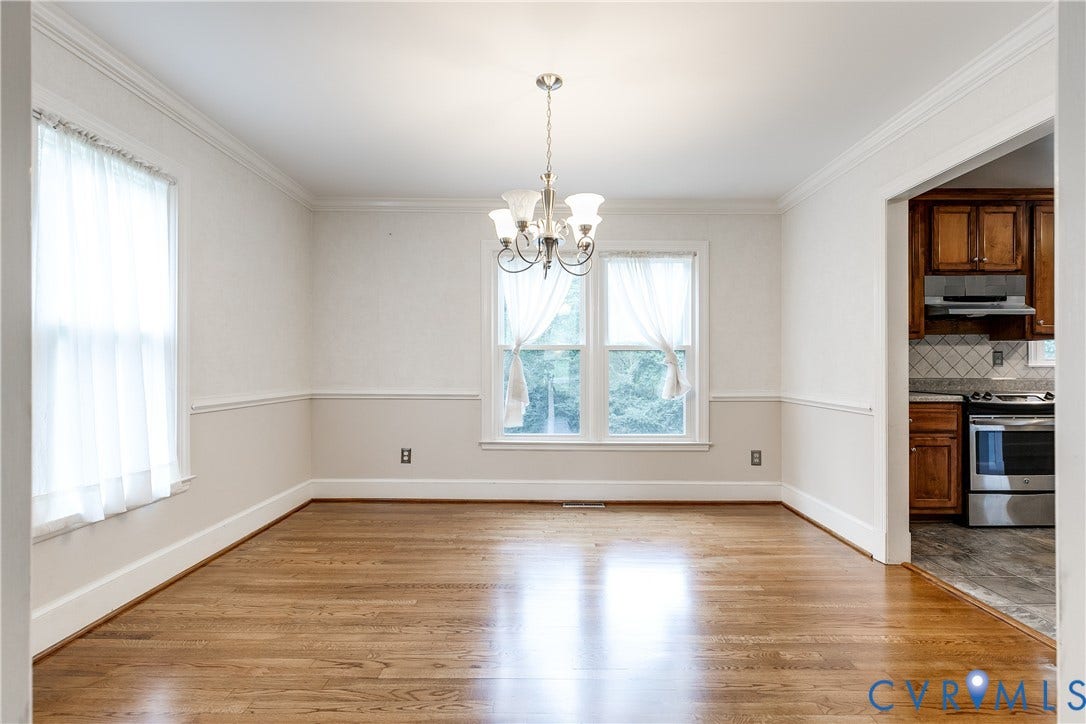 3924 Belspring Road, Chester, VA 23831 Spacious room featuring wood-finish flooring, two windows, crown molding, chair rail molding, and a chandelier