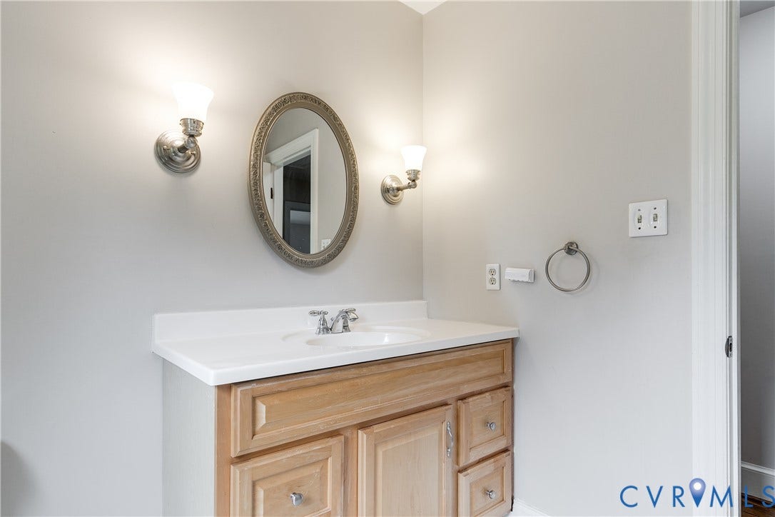 3924 Belspring Road, Chester, VA 23831 Single vanity featuring a light wood-finish cabinet with silver hardware, white countertop, and a circular undermount sink