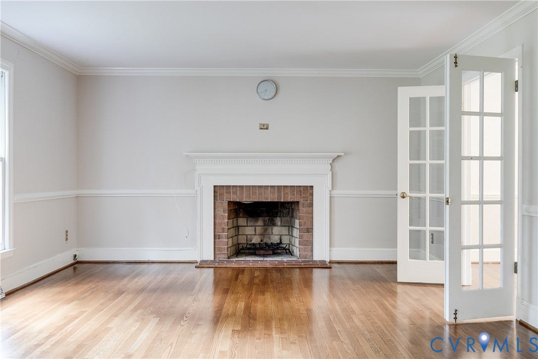 3924 Belspring Road, Chester, VA 23831 Hardwood flooring throughout featuring a traditional brick fireplace with a white mantel, crown molding, and two-panel French doors