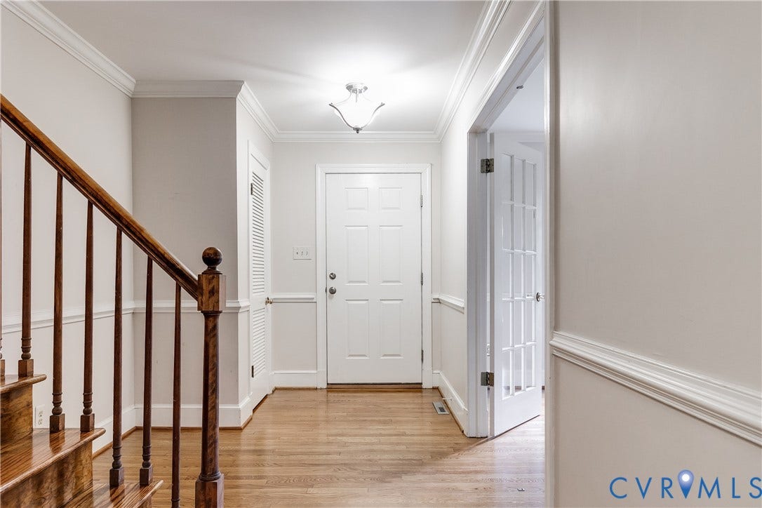3924 Belspring Road, Chester, VA 23831 Entry foyer featuring wood-finish flooring, a white paneled entry door, crown molding, and a traditional staircase with wood newel and balusters