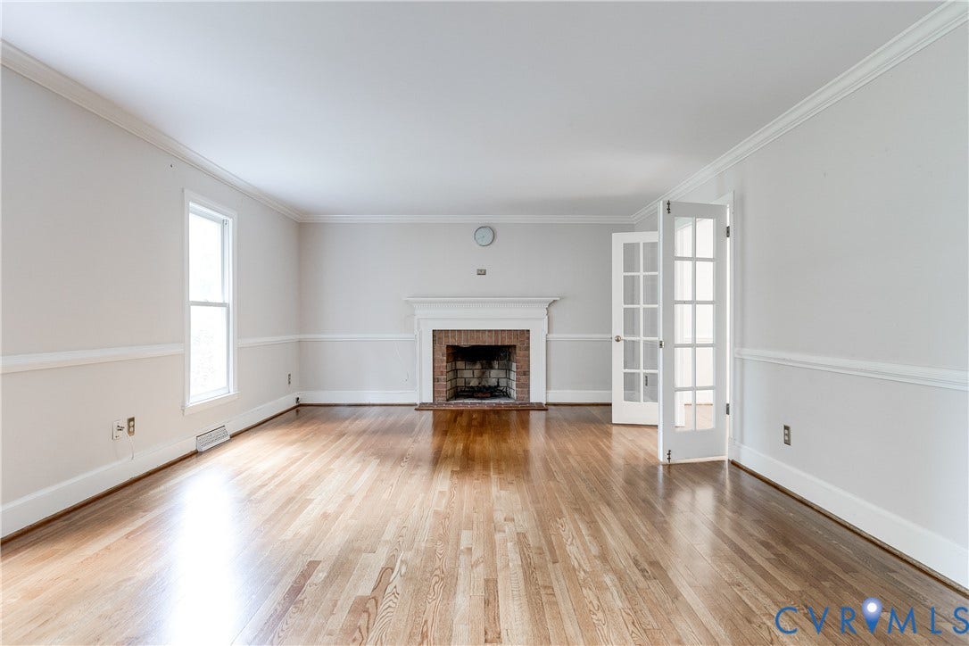 3924 Belspring Road, Chester, VA 23831 Expansive room featuring wood-finish flooring, a brick fireplace with a white mantel, and elegant crown molding
