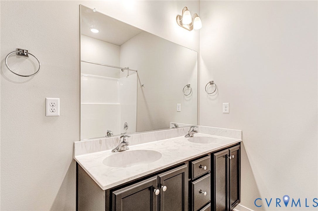 Dual vanity with dark wood-finish cabinetry and white countertops