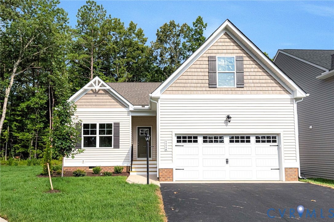 Contemporary home exterior featuring white siding, a shingled gable, and decorative shutters