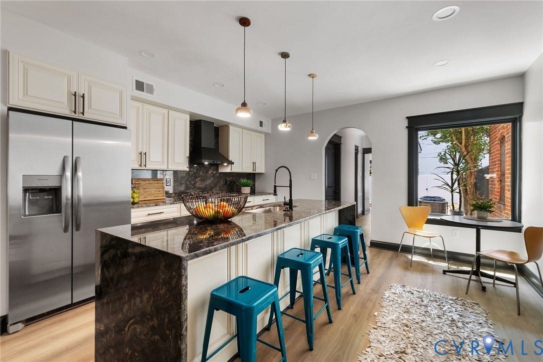 2627 Kensington Avenue, Museum District, Richmond, VA 23220 Open-concept kitchen featuring an oversized island, stainless steel appliances, dark stone countertops, wood-finish flooring, and pendant lighting