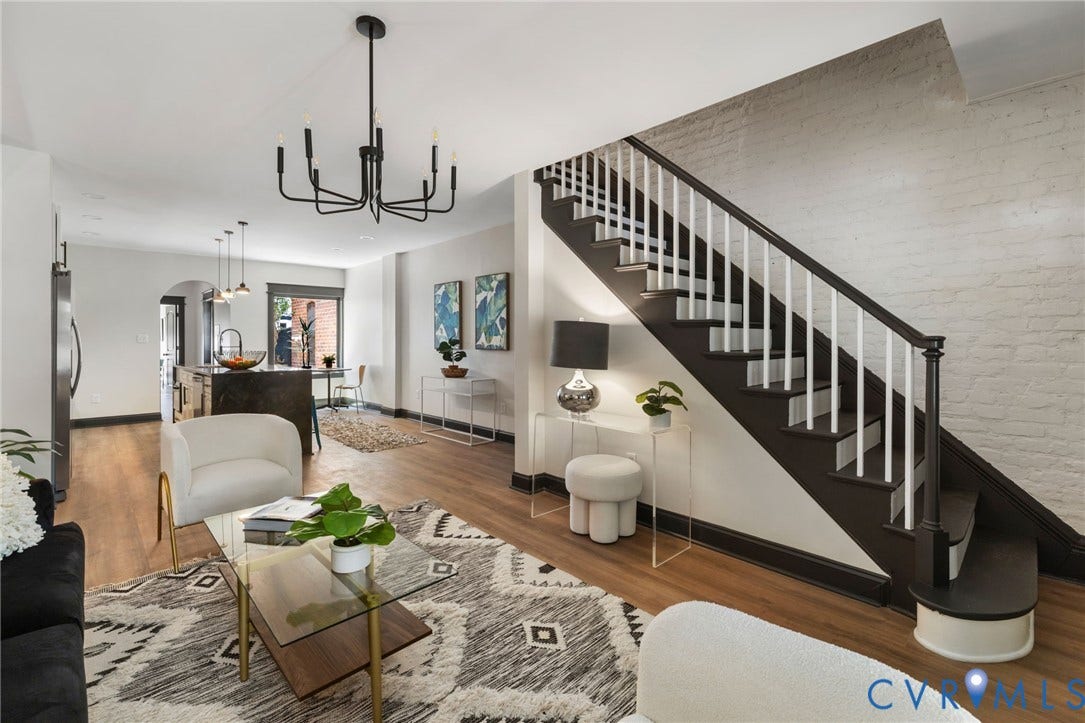 2627 Kensington Avenue, Museum District, Richmond, VA 23220 Open-concept living space featuring wood-finish flooring, a modern black chandelier, and a dark stained staircase with white balusters