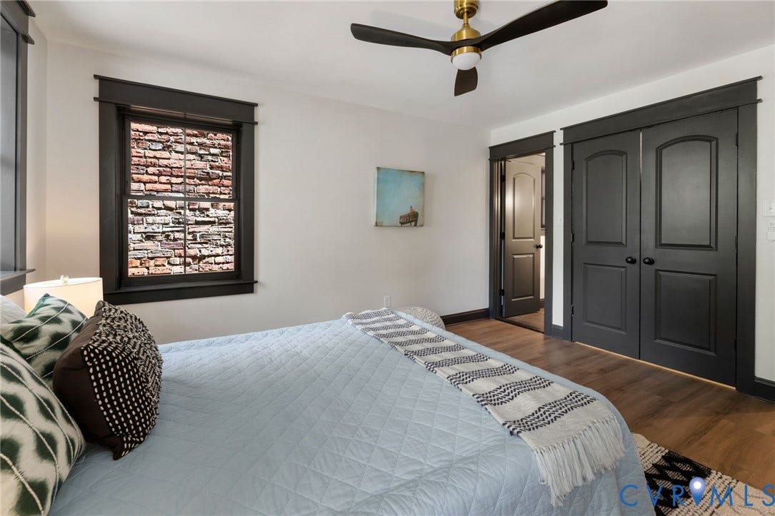 2627 Kensington Avenue, Museum District, Richmond, VA 23220 Bedroom featuring dark-framed window, two-panel bifold closet doors, wood-finish flooring, and a ceiling fan with integrated lighting