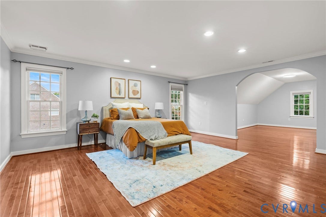 Expansive room featuring rich wood-finish flooring, recessed lighting, and crisp white trim