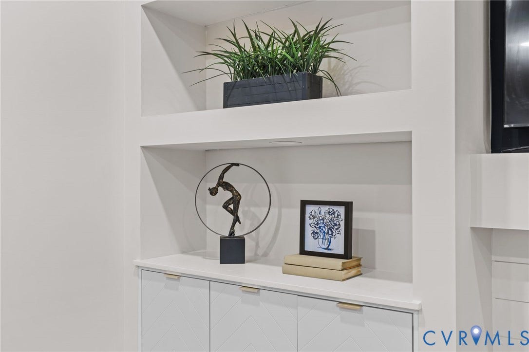 Built-in cabinetry with geometric panel details, a light-toned countertop, and recessed shelving