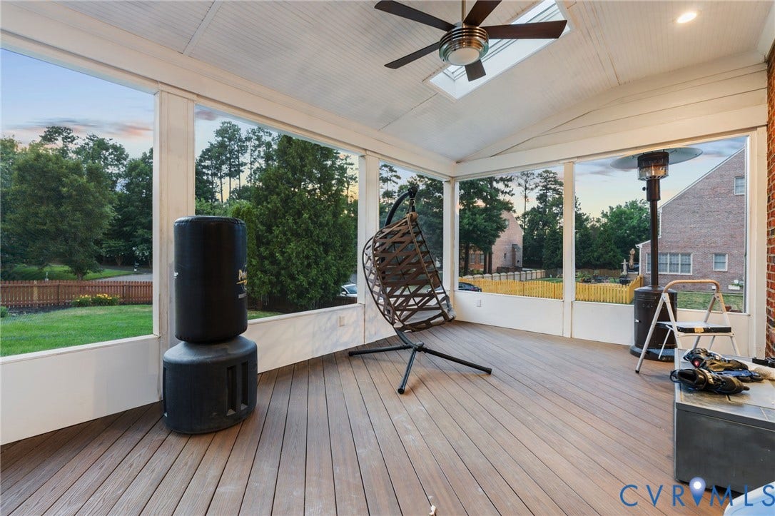 Screened porch featuring a vaulted beadboard ceiling with a skylight and ceiling fan