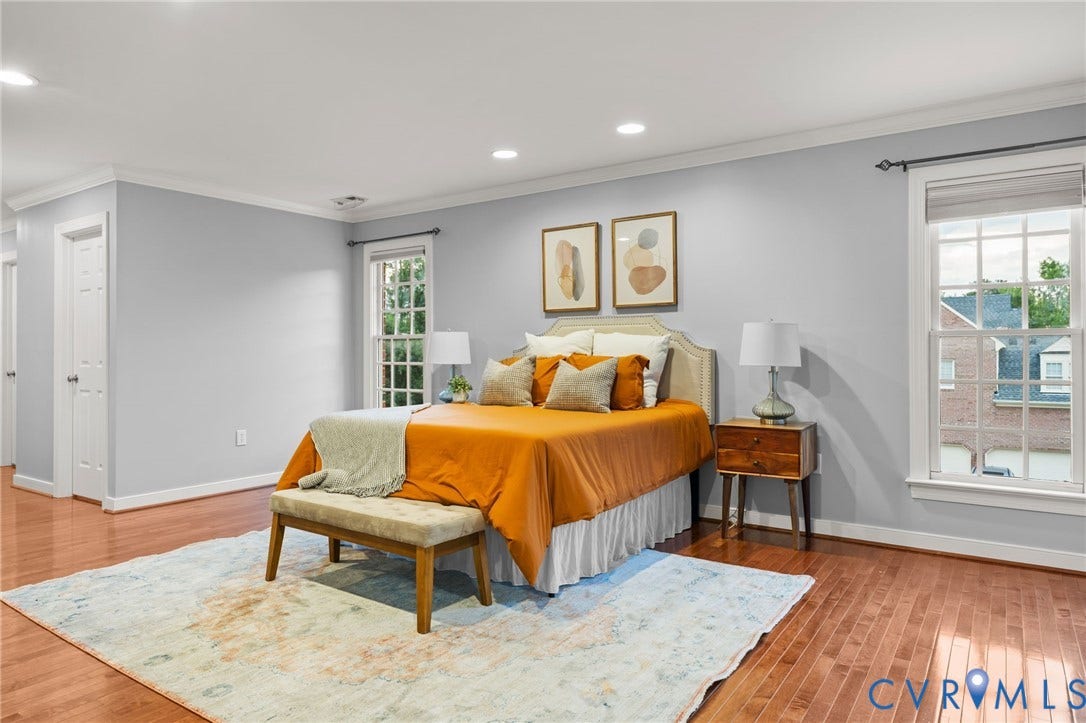 Spacious room featuring wood-finish flooring, recessed lighting, crown molding, and two multi-pane windows