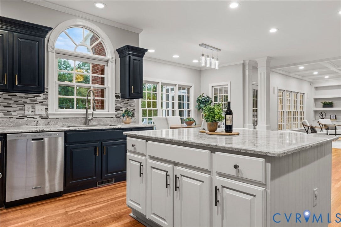 Kitchen featuring a large central island with light-toned cabinetry, granite countertops, and wood-finish flooring