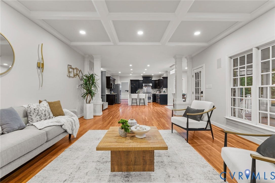 Spacious living area featuring coffered ceilings, recessed lighting, and rich wood-finish flooring