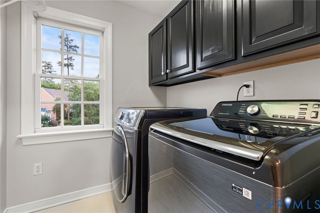 Laundry area with cabinetry featuring dark wood-finish doors and a wood-finish shelf