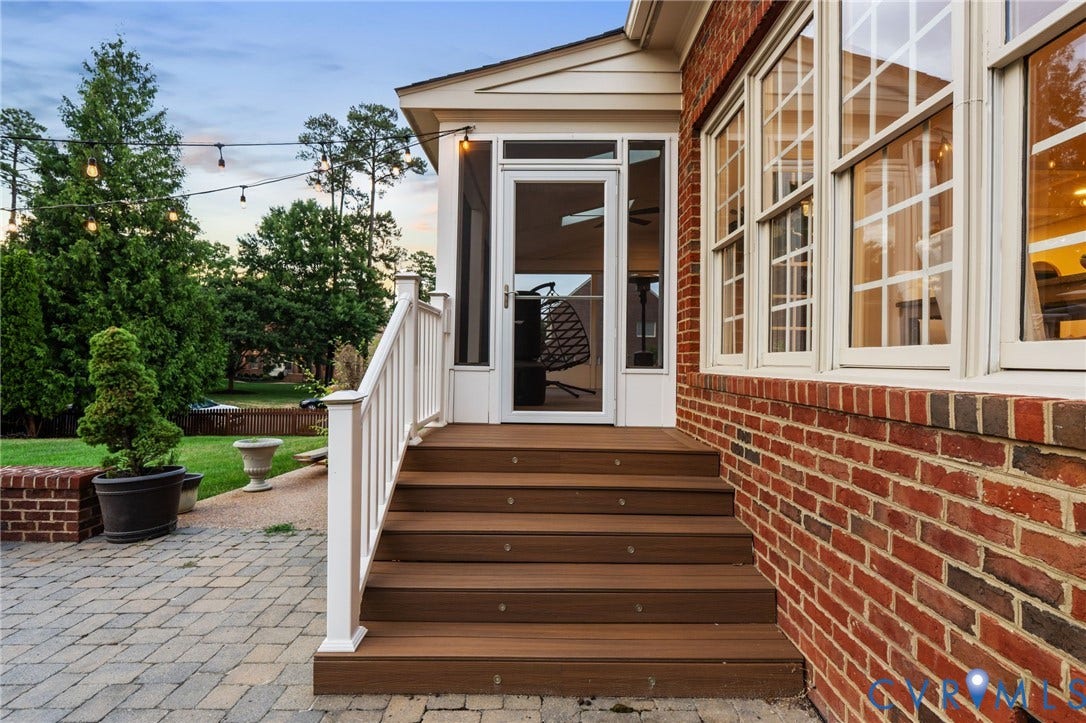 Screened porch entry with wood-finish steps and white railing