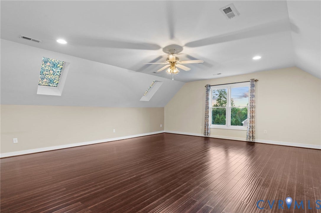 Spacious room featuring wood-finish flooring, recessed lighting, and a ceiling fan
