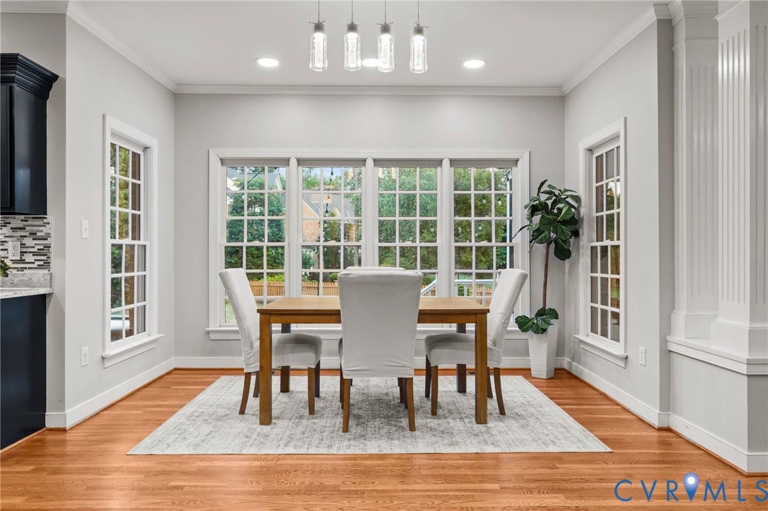 Dining area featuring wood-finish flooring, a multi-pane window wall, recessed lighting, and a contemporary linear chandelier