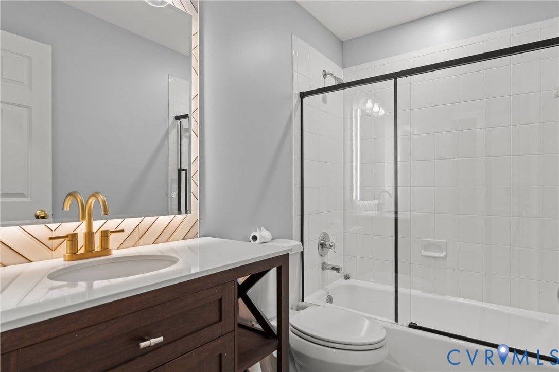 Bathroom featuring a dark wood-finish vanity with a white countertop and undermount sink