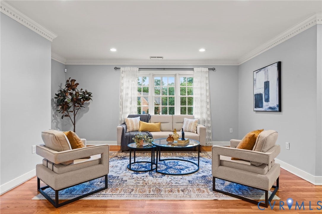 Living area featuring hardwood flooring, crown molding, recessed lighting, and a large window with white casing