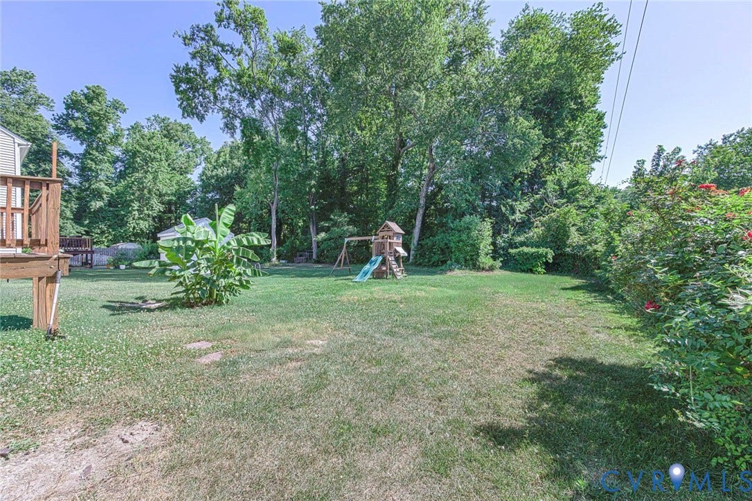 1900 Brilland Court, Glen Allen, VA 23060 Expansive grassy yard with mature trees, a wooden deck, and a detached shed