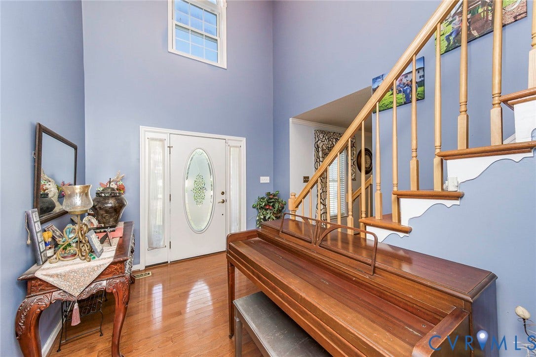 1900 Brilland Court, Glen Allen, VA 23060 Double-height entry foyer featuring wood-finish flooring, a white paneled door with an oval etched glass insert, and sidelight windows