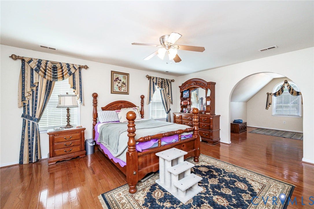 1900 Brilland Court, Glen Allen, VA 23060 Spacious room featuring wood-finish flooring, a ceiling fan, and an arched doorway leading to an additional area with a window