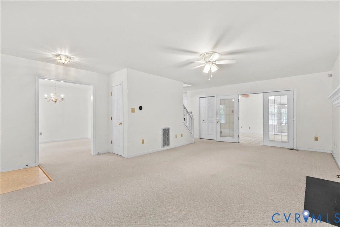 2924 Warfield Ridge Terrace, Chester, VA 23831 Expansive carpeted room featuring a ceiling fan, a fireplace with a black hearth, and white trim