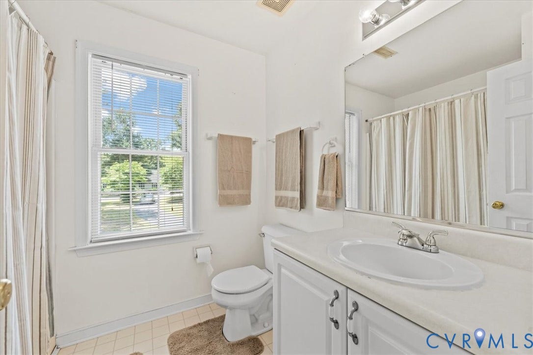 2924 Warfield Ridge Terrace, Chester, VA 23831 White bathroom featuring a single-pane window with blinds, a vanity with a white countertop and integrated sink, and a shower with a curtain