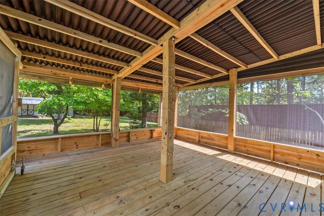 2924 Warfield Ridge Terrace, Chester, VA 23831 Expansive screened porch featuring wood-finish flooring, exposed wood beam ceiling, corrugated metal roof, and a low wood wall