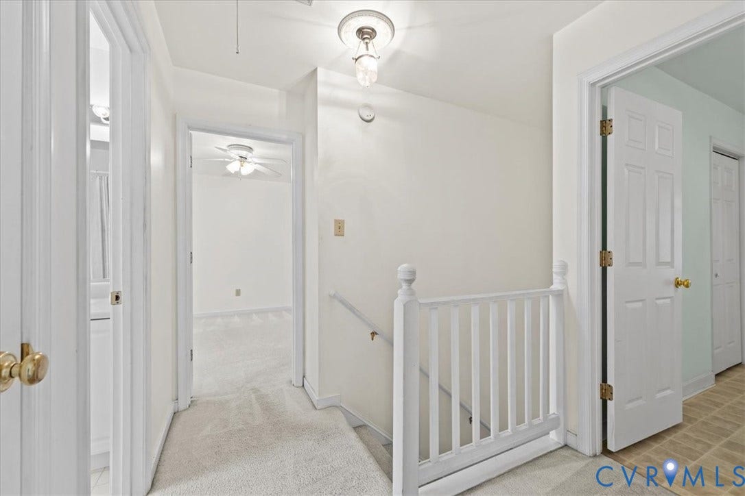 2924 Warfield Ridge Terrace, Chester, VA 23831 Carpeted hallway featuring a white banister, a flush-mount light fixture, and three panel doors