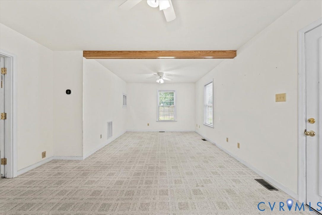 2924 Warfield Ridge Terrace, Chester, VA 23831 Spacious interior room featuring light-toned patterned carpet and a contrasting exposed wood beam