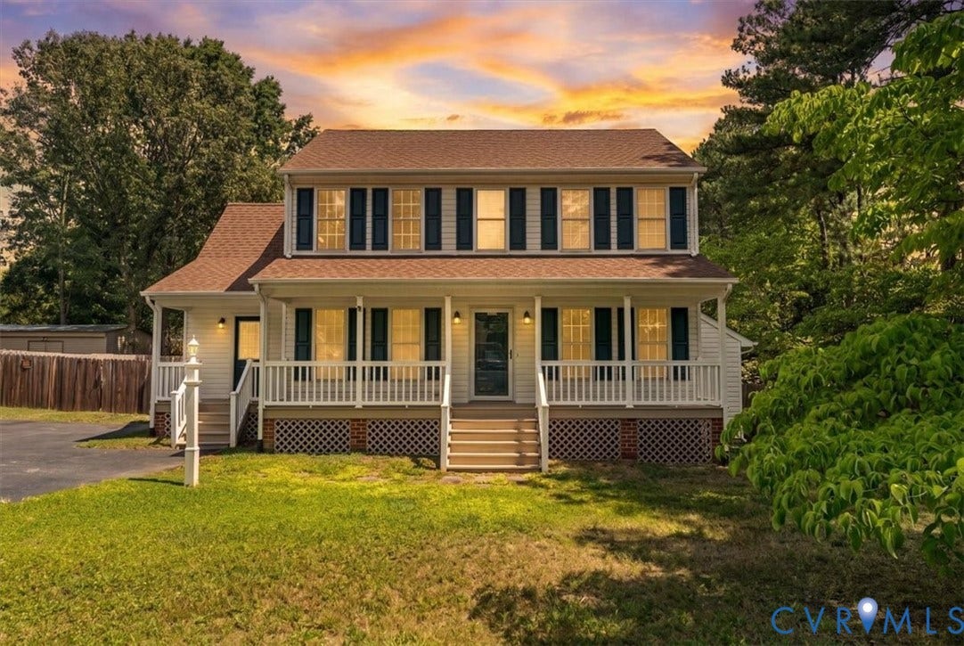 2924 Warfield Ridge Terrace, Chester, VA 23831 Two-story residence featuring a covered front porch with white railings, dark shutters, a brown shingle roof, white siding, and mature surrounding trees