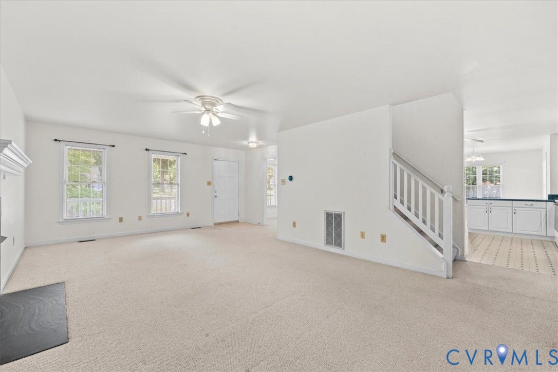 2924 Warfield Ridge Terrace, Chester, VA 23831 Spacious living area featuring light-toned carpeting, white walls, multiple windows, and a ceiling fan